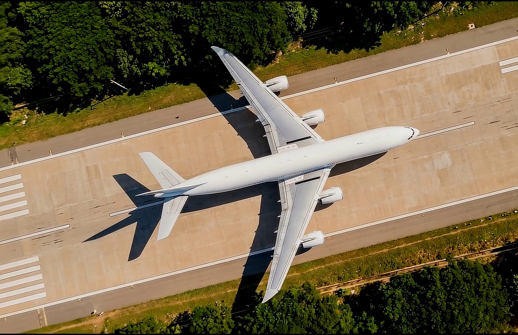 A wide-body airliner on an airport runway, seen from directly overhead