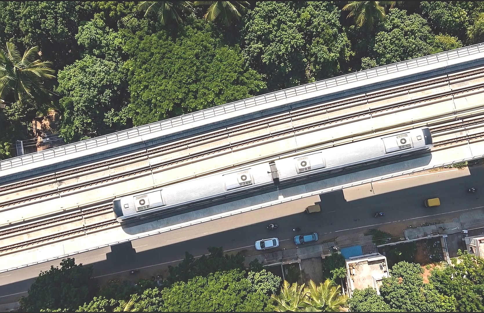 An elevated metro viaduct carrying a train, seen from directly overhead