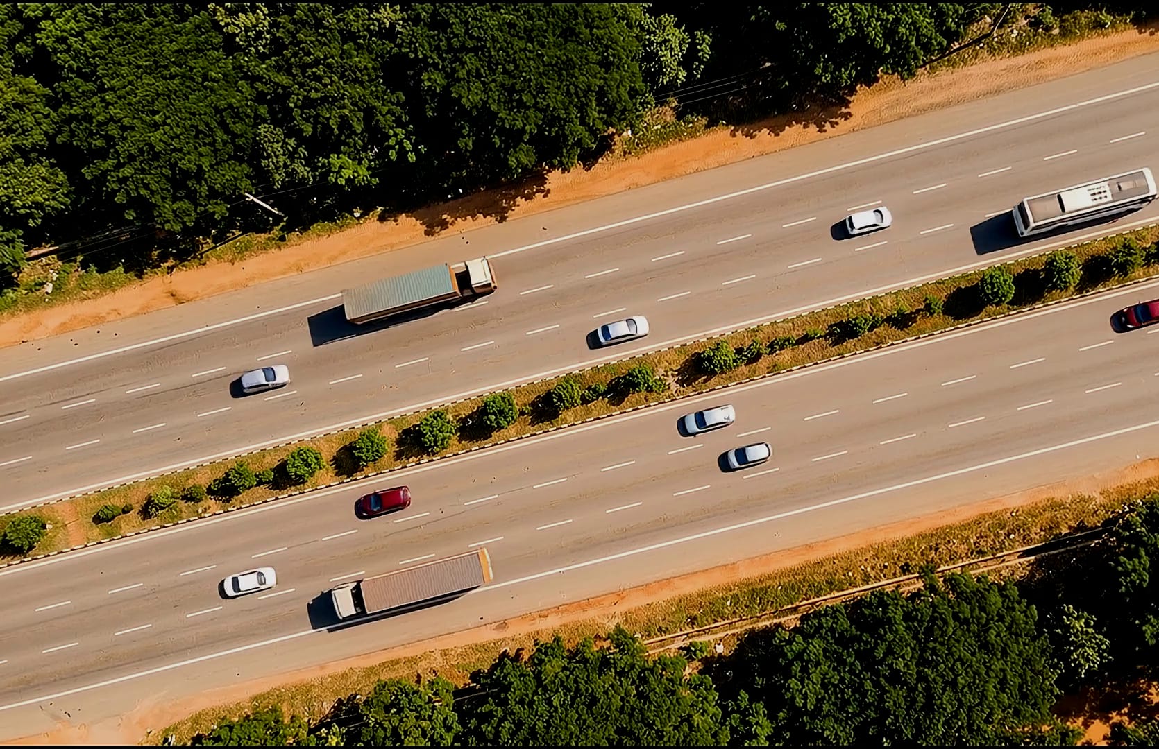 A six-lane divided expressway carrying traffic, seen from directly overhead